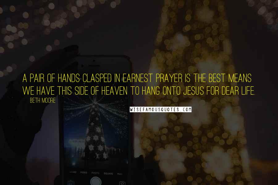 Beth Moore Quotes: A pair of hands clasped in earnest prayer is the best means we have this side of heaven to hang onto Jesus for dear life.